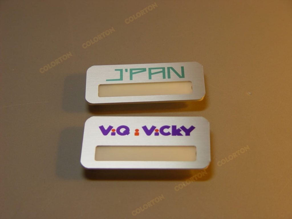 Изображение двух металлических бейджиков с окошком Jpan и Viqivicky